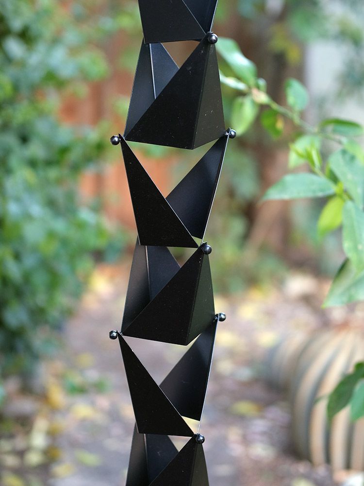 Black Origami Rain Chain. Hand crafted 304 stainless steel. Matte black powder coat. 8ft section with 27 cups. 4-1/2" x 4" x 2-1/2" cups. Geometric angular design. V-hook included. Contractor DIY. Damascus OR.