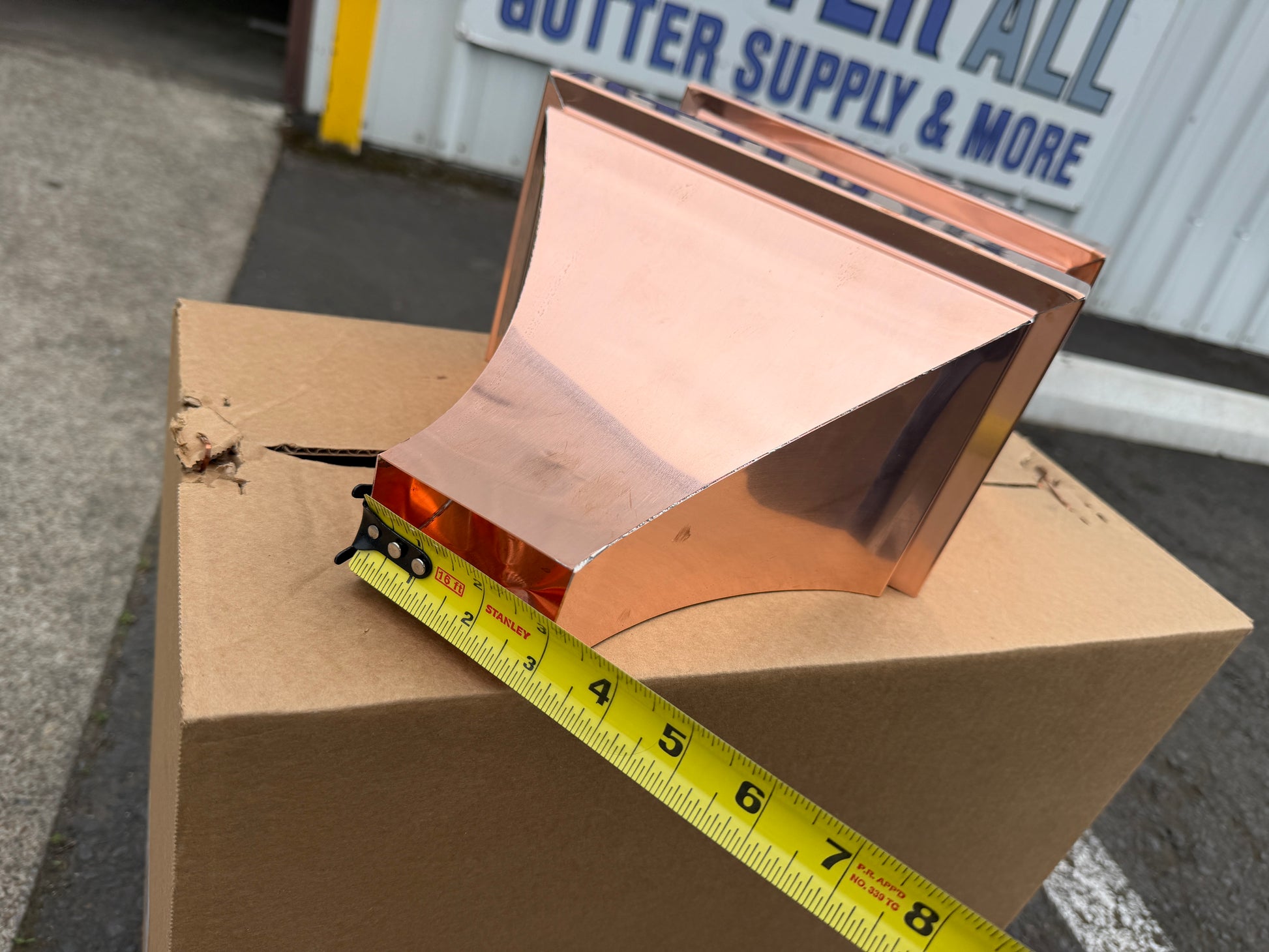 Small copper conductor head single crown style 10x6x13 inch leader head rain collector box featuring single crown top smooth curved face decorative bands and 2x3 square downspout outlet in bright mill finish 16 oz copper by GutterAll Damascus Oregon