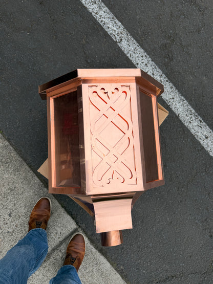 Ornamental copper conductor head with scroll cut decorative lattice front panel 18x8.5x20 inch leader head rain collector box featuring peaked gabled top faceted hexagonal body and 2x3 oval downspout outlet in bright mill finish 16 oz copper by GutterAll Damascus Oregon