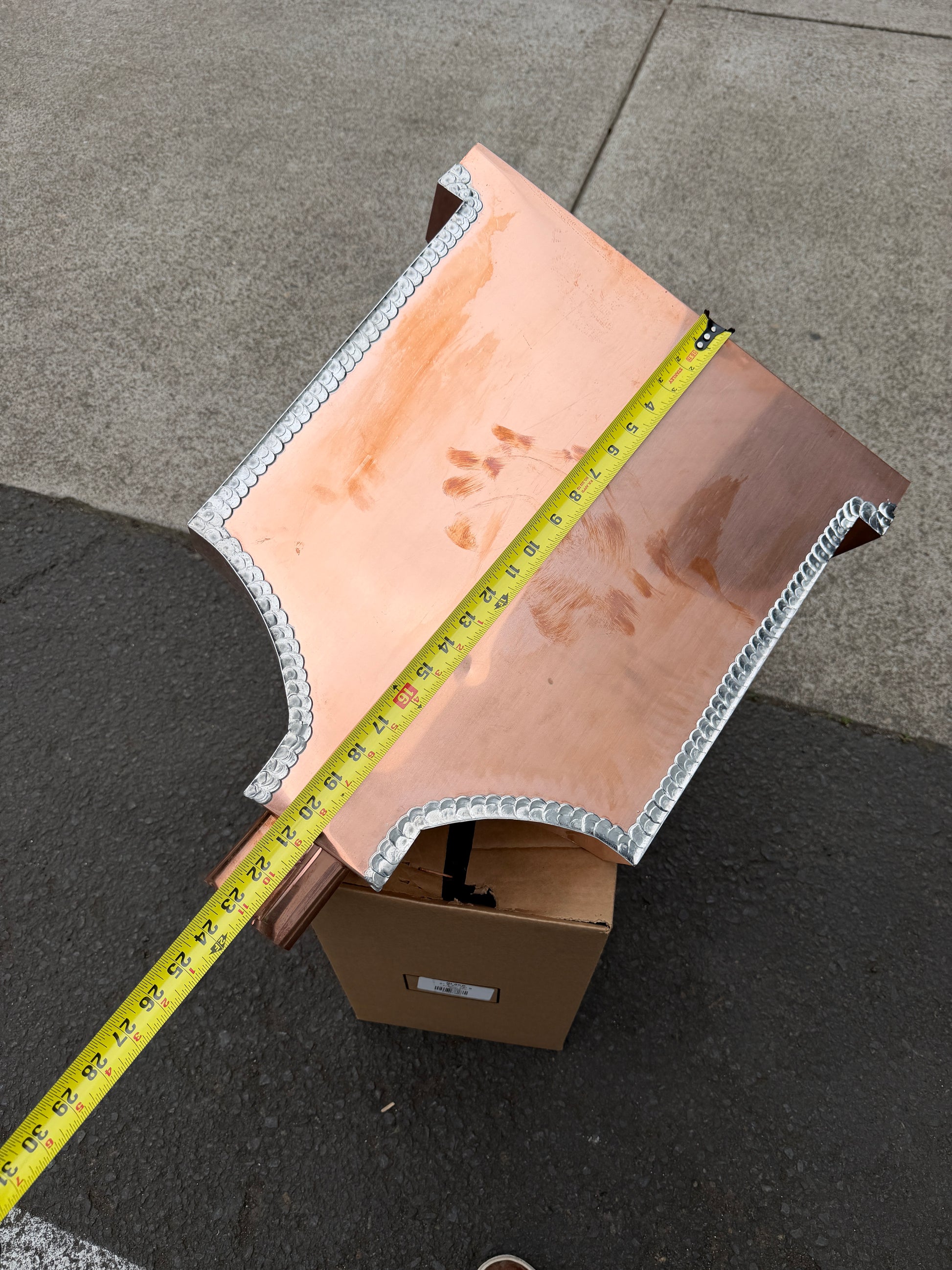 Ornamental copper conductor head with scroll cut decorative lattice front panel 18x8.5x20 inch leader head rain collector box featuring peaked gabled top faceted hexagonal body and 2x3 oval downspout outlet in bright mill finish 16 oz copper by GutterAll Damascus Oregon