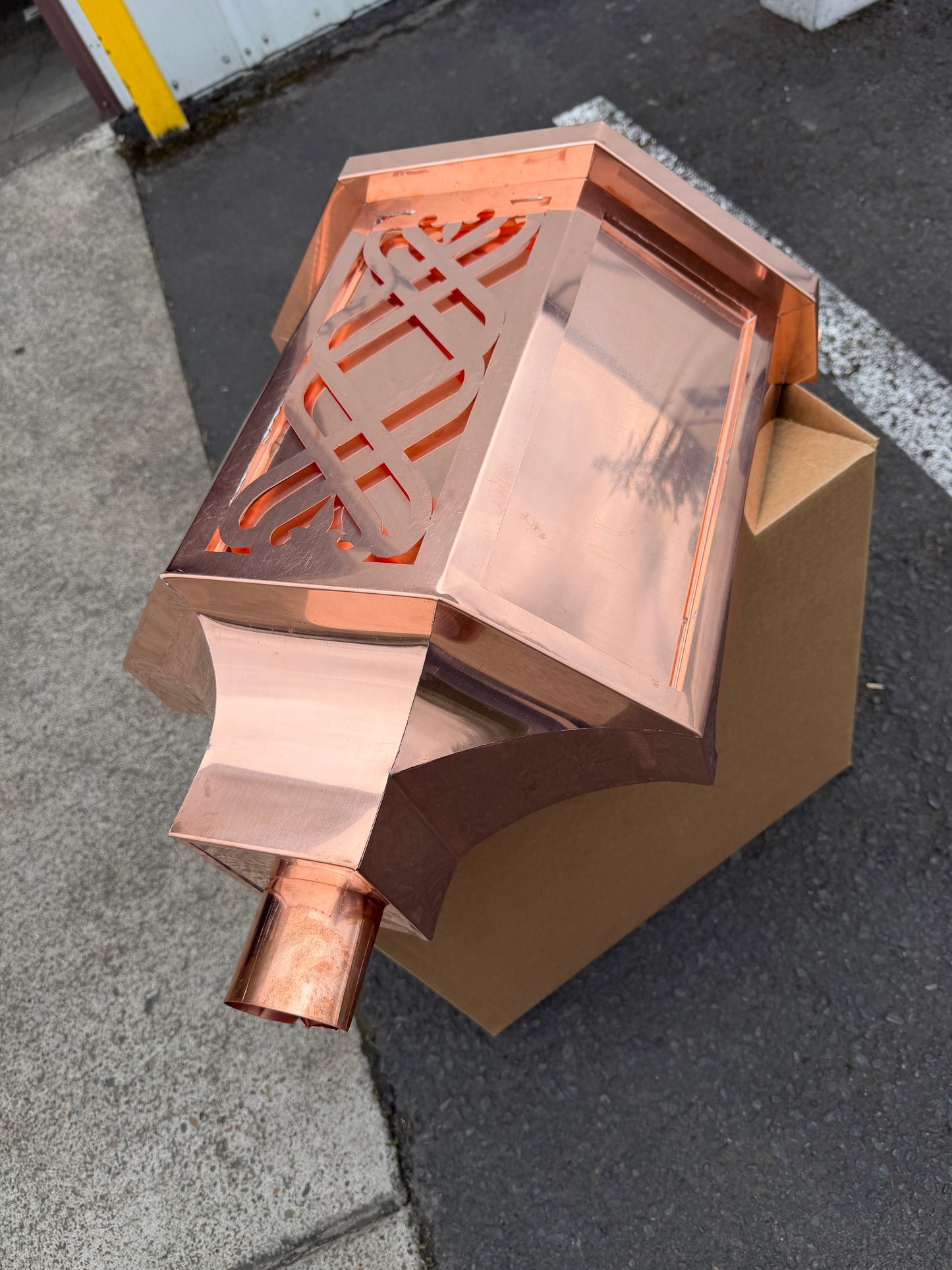 Ornamental copper conductor head with scroll cut decorative lattice front panel 18x8.5x20 inch leader head rain collector box featuring peaked gabled top faceted hexagonal body and 2x3 oval downspout outlet in bright mill finish 16 oz copper by GutterAll Damascus Oregon