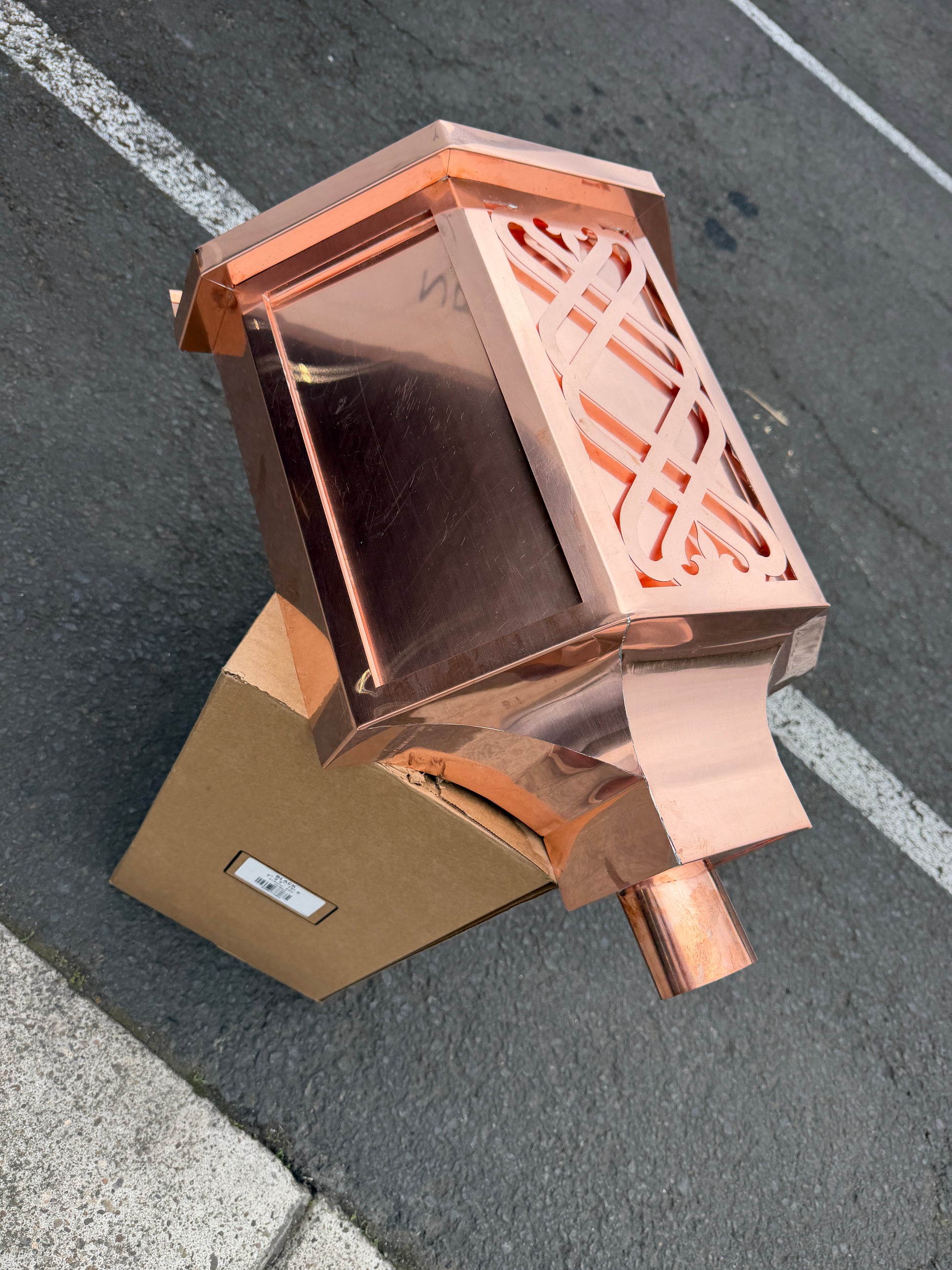 Ornamental copper conductor head with scroll cut decorative lattice front panel 18x8.5x20 inch leader head rain collector box featuring peaked gabled top faceted hexagonal body and 2x3 oval downspout outlet in bright mill finish 16 oz copper by GutterAll Damascus Oregon