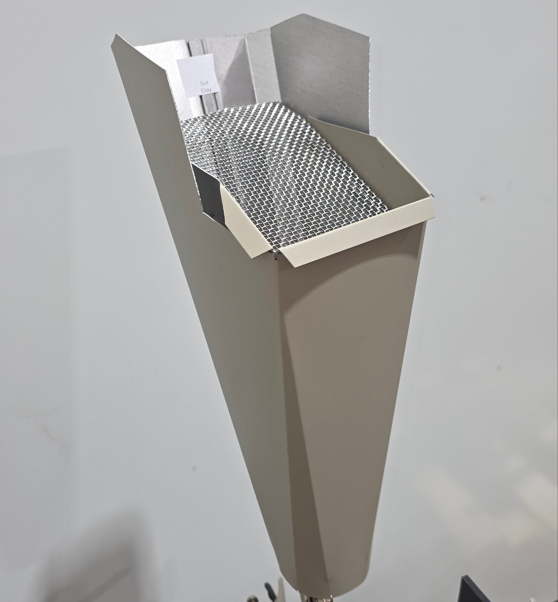 Clay aluminum gutter downspout cleanout with debris screen filtering leaves before the downspout.