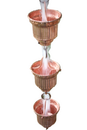 Copper rain chain with cascading water flowing through decorative cups.