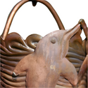 Close-up of copper dolphin design on decorative rain chain cup.