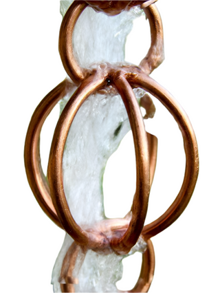 Close-up of copper-finished rain chain with water flowing through.