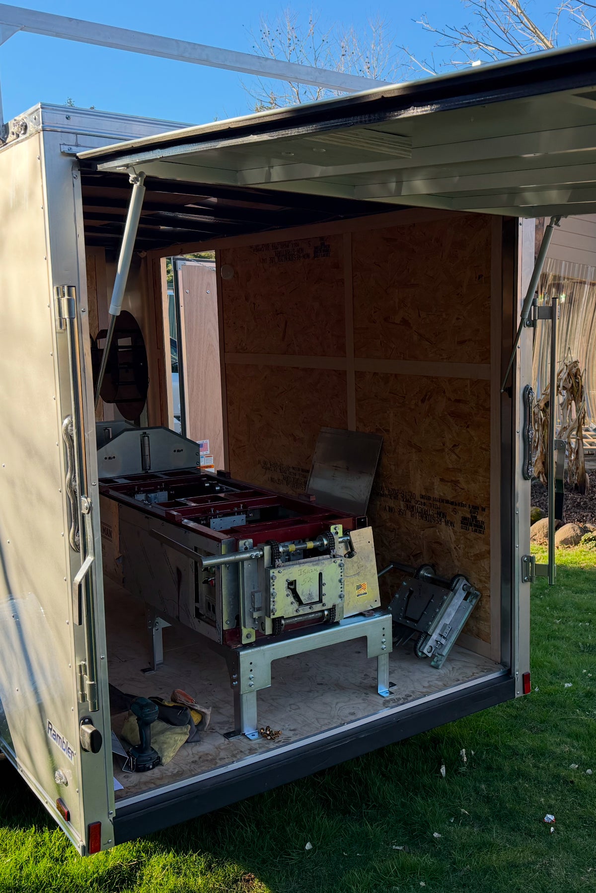 Enclosed gutter trailer with rear door converted to lift upward over seamless gutter machine using heavy-duty gas struts GutterAll Damascus Oregon