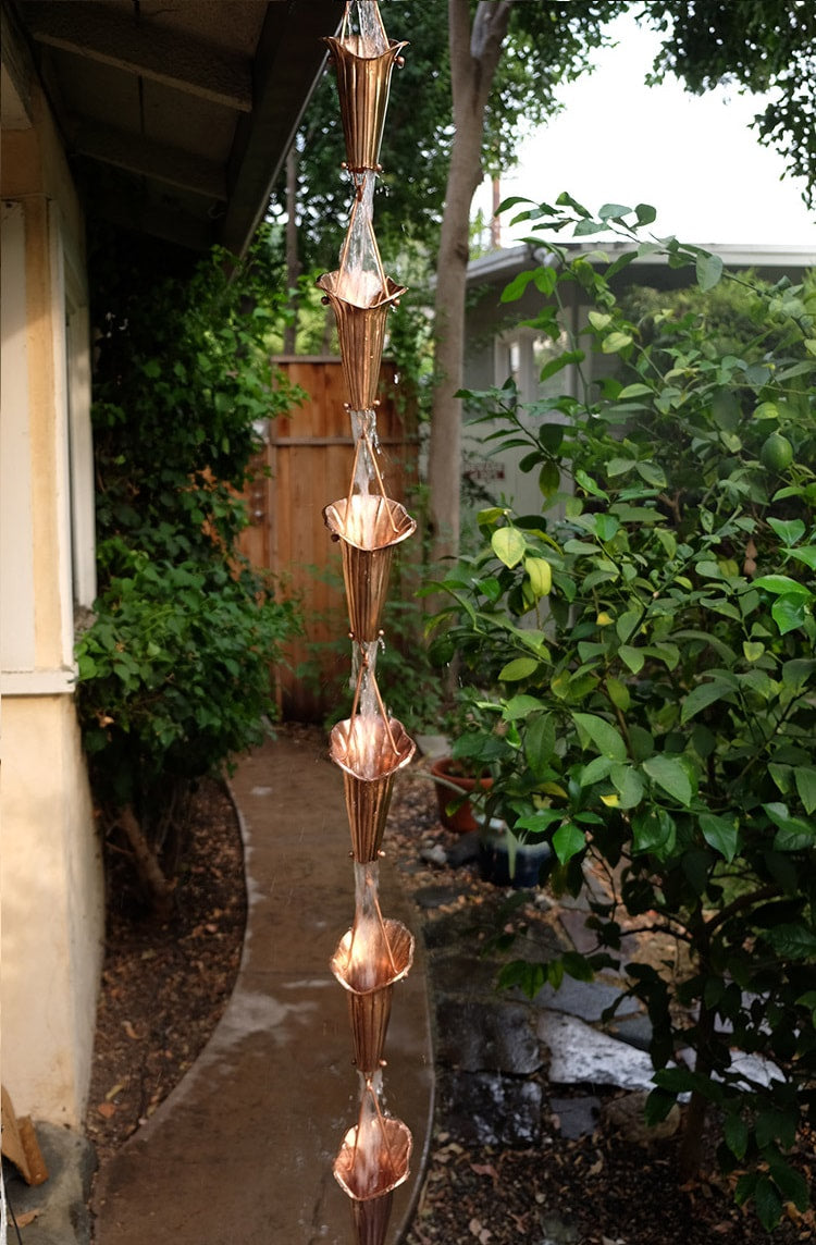 Handcrafted copper Lotus Flower Rain Chain showcasing intricate petal design and water flow in a garden setting