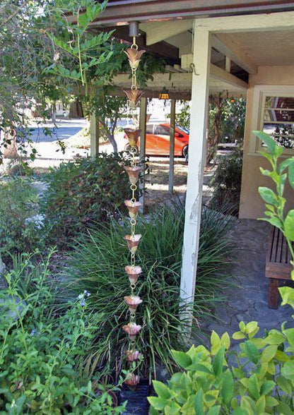 Cast Flower 2.0 rain chain installed on a house, enhancing the garden decor.