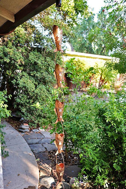 Full view of copper koi fish rain chain installed as a decorative downspout.
