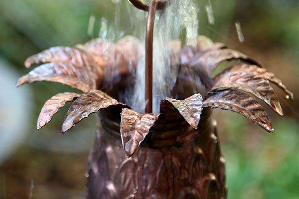 Handcrafted copper pineapple rain chain with detailed leaf crown and natural patina finish