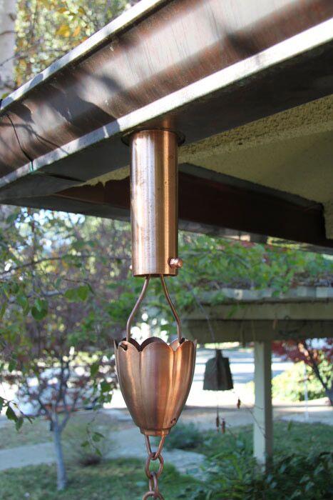 Installed copper rain chain mounting system on a gutter for secure attachment.