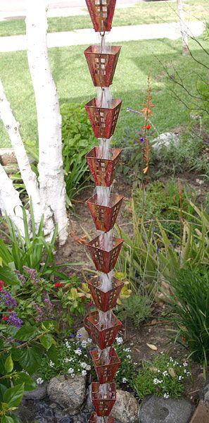 Full view of copper Japanese box rain chain in a garden setting.