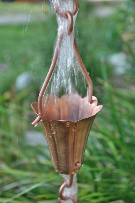 Decorative tulip copper rain chain with water cascading through the cup design.