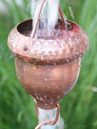 Close-up of copper oaknut cup rain chain with water cascading through.
