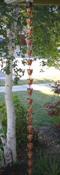 Full view of a decorative copper rain chain hanging outdoors.