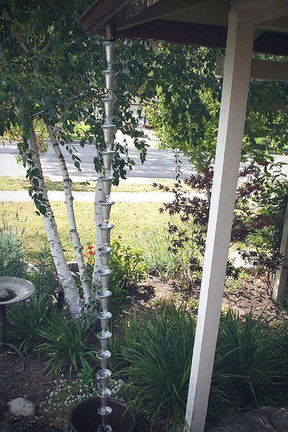 Full view of a simple spotted bell cup rain chain installed on a porch.