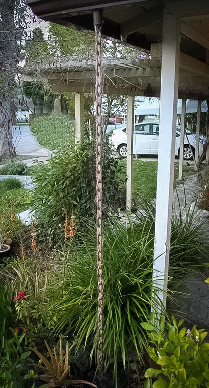Full view of copper rain chain installed as a decorative downspout alternative.