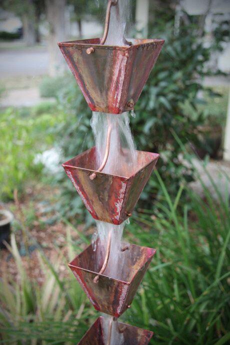 Traditional copper patina rain chain with square cups creating a water feature.