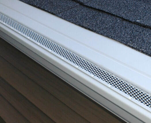 White professional-grade micro-mesh gutter guard installed on roof edge.