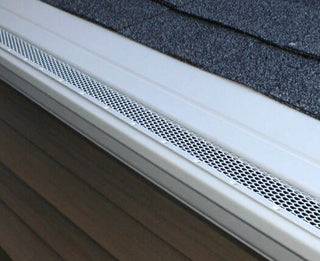 White professional-grade micro-mesh gutter guard installed on roof edge.
